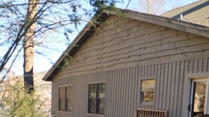 A wooden cabin with a stone staircase leading to a deck.