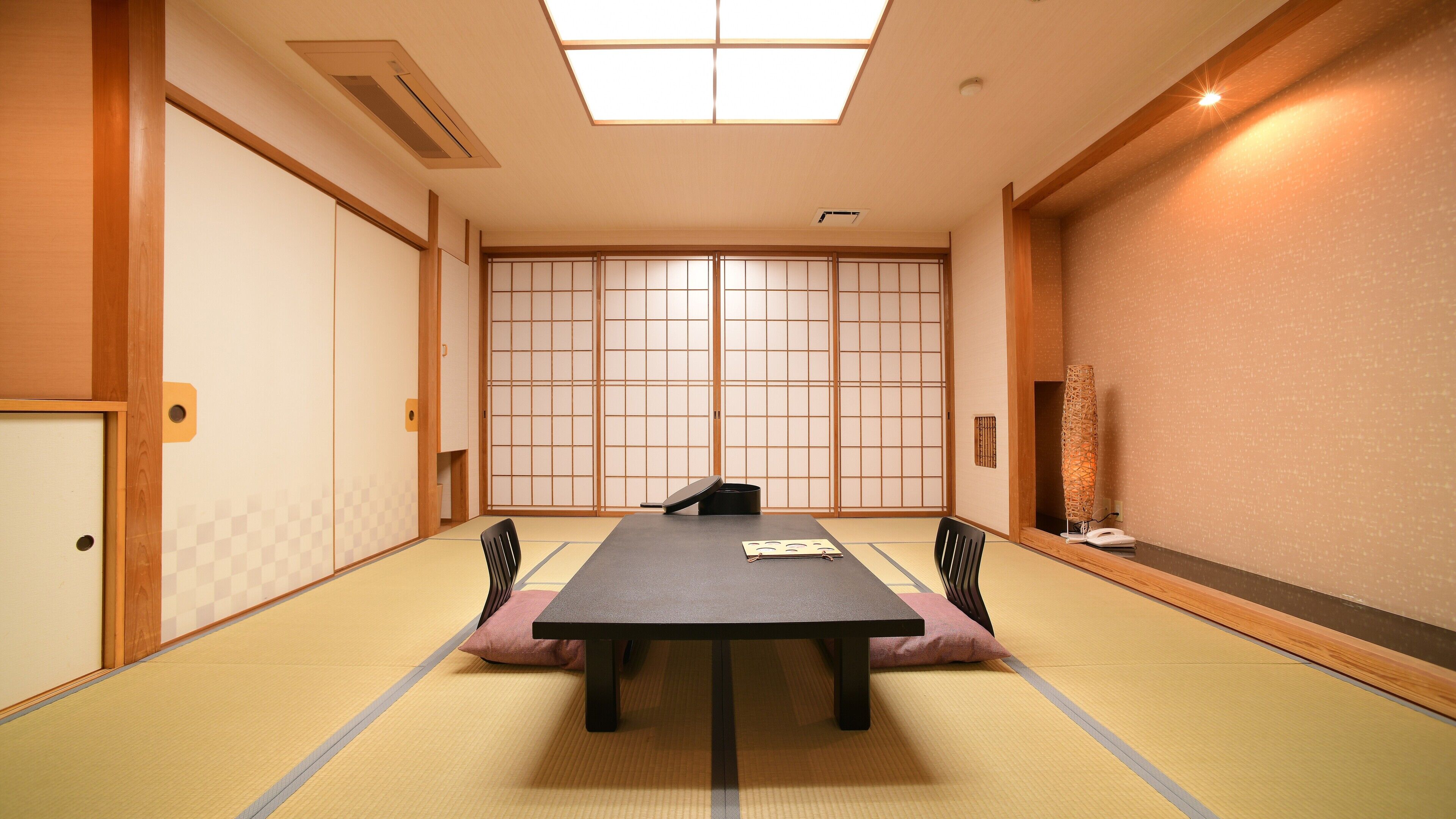 A traditional Japanese room with tatami flooring, a low table, and shoji screens.