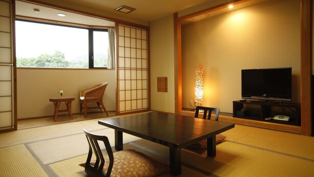 A traditional Japanese room with tatami flooring, a low table, chairs, a television, and a sliding door leading to another room. - Sadasuke (Kami)