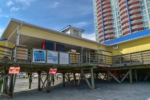 Um píer à beira-mar com um letreiro para Cherry Grove Pier, um café no calçadão e um resort privativo.
