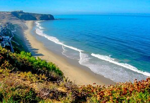 A coastal landscape with a sandy beach, a cliff, and a clear blue sky. - California Beach Retreat - Clean, Quality Beds, Great Bathrooms & Kitchen!  (Dana Point)