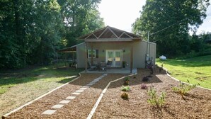 A single-story house with a covered porch, a small garden with stepping stones, and a lawn.
