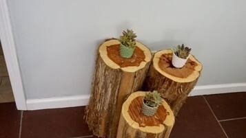 Drie houten tafels op boomstompjes, met potplanten.