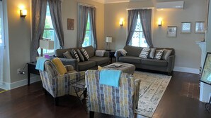 A living room with a sofa set, a patterned armchair, a coffee table, and a rug. - Historic Petunia Cottage: Large Renovated Victorian Excellent In-town Location (Bar Harbor)
