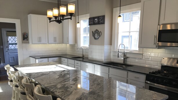 A modern kitchen with a large island, white cabinetry, stainless steel appliances, and pendant lighting. - Historic Petunia Cottage: Large Renovated Victorian Excellent In-town Location (Bar Harbor)