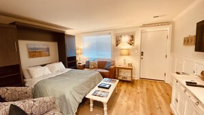 Ein Schlafzimmer mit einem Bett, einer Couch, einem kleinen Tisch, einer Lampe und einer Tür mit der Aufschrift 'Wrightsville Beach'.