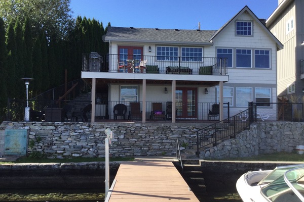 House from the water. Sun and shaded seating. Gas fire pit w/ chairs on the left