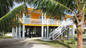 A two-story building with a balcony and a staircase. - PRIVATE LUXURY, Beachfront Home, Hot Tub, Kayaks, Paddle Board, Cabana (Casuarina Point)