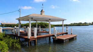 A dock with a covered pavilion, wooden benches, and a boat. - "Your Own Private Resort" at 9 Oaks!            (New Smyrna Beach)