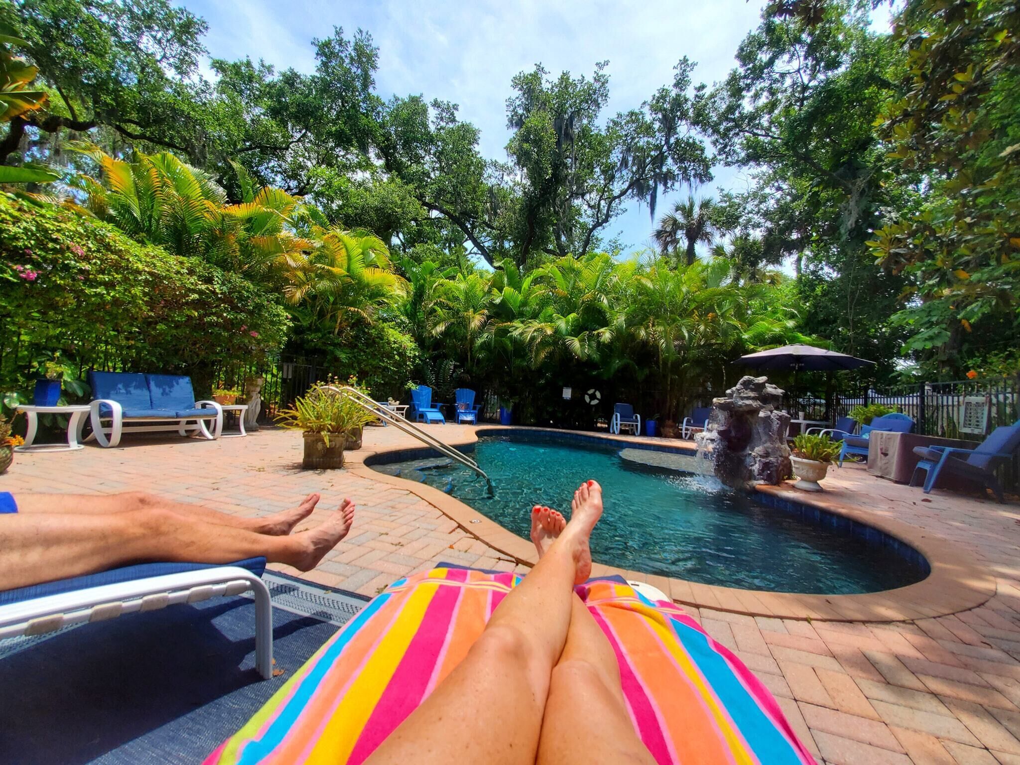 A pool area with lounge chairs and a small waterfall feature.