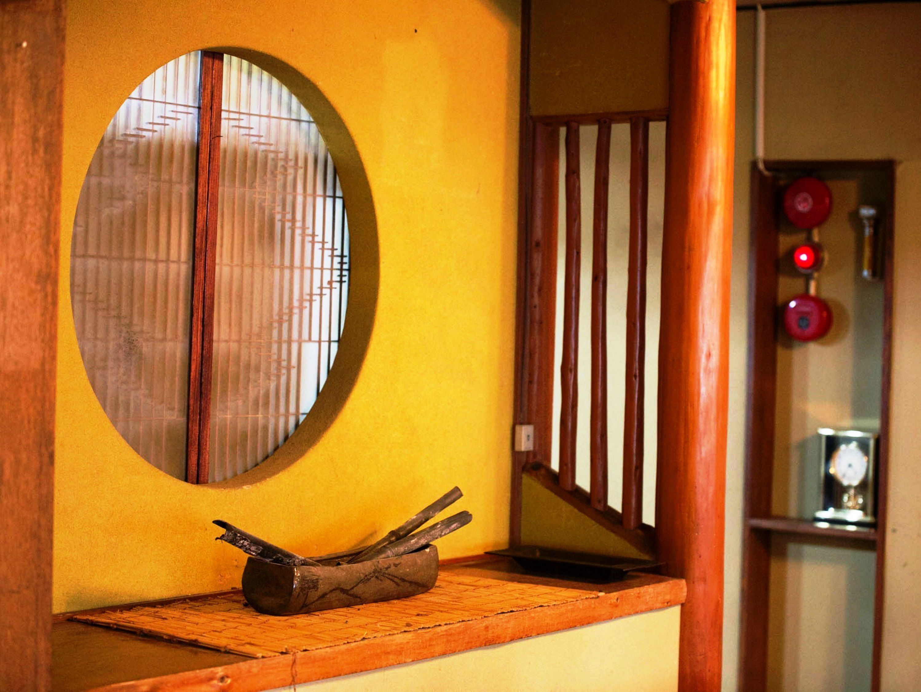 A wooden bench with a circular window and a metal railing.