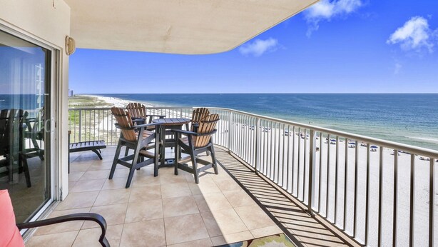 A balcony with a table and chairs, overlooking a beach and ocean. - Admirals Quarters 4BR..4BA, 2120sf, STUNNING VIEWS (Orange Beach)