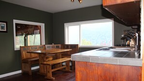 Una cocina con armarios de madera, un banco empotrado y un ventanal.