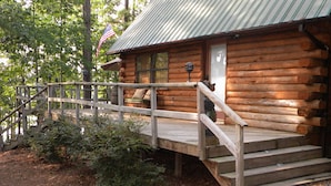 Eine Blockhütte mit einer Holzdiele und einem Metalldach.