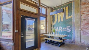 Una puerta de madera con un panel de vidrio, una mesa de picnic con bancos y un mural en la pared.