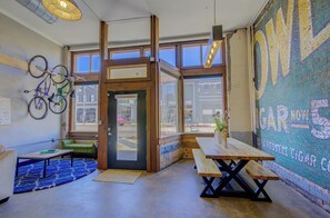 En café med træborde, en blåt mønstret måtte og cykler på væggen.