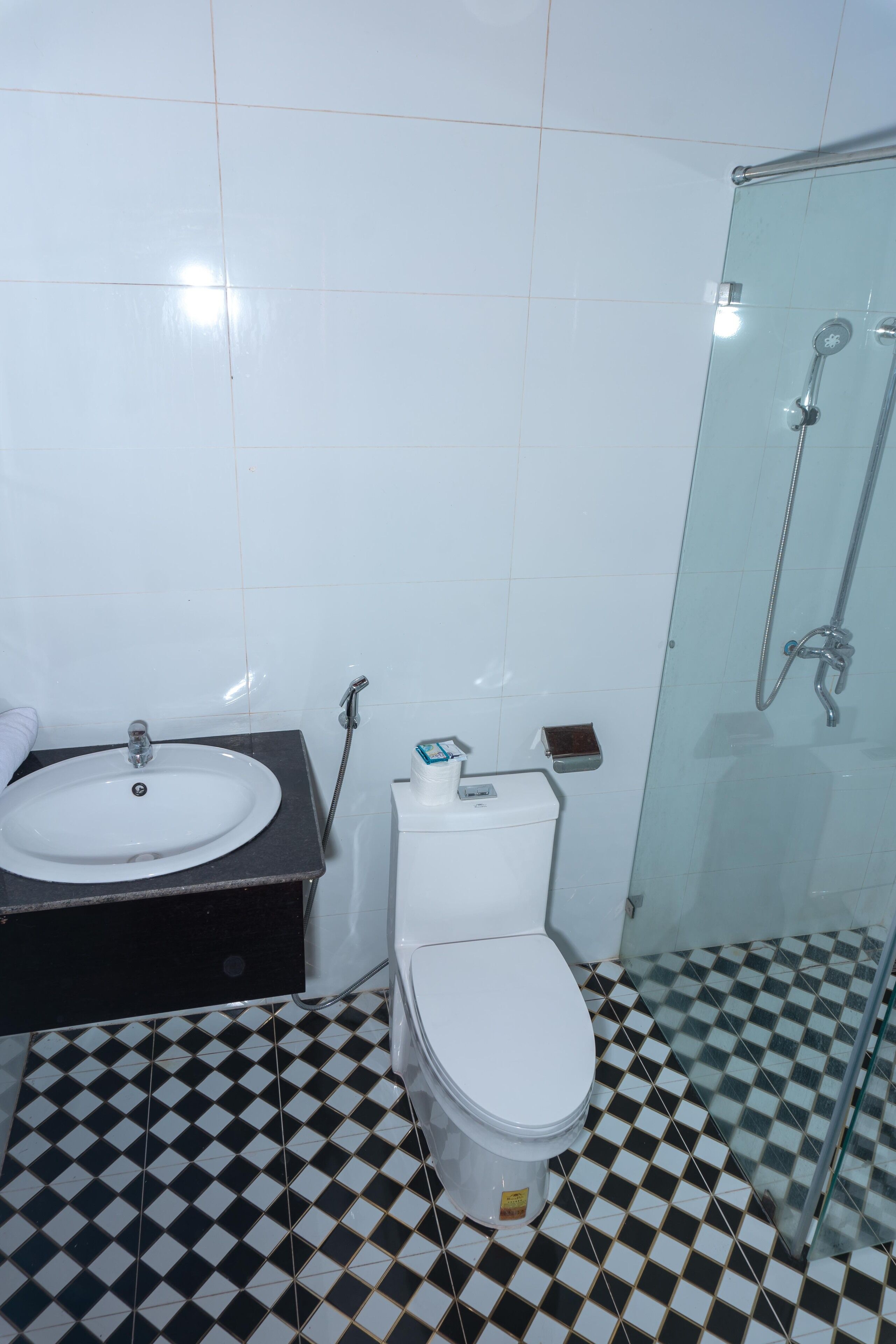 A bathroom with a white sink, toilet, and glass shower enclosure.