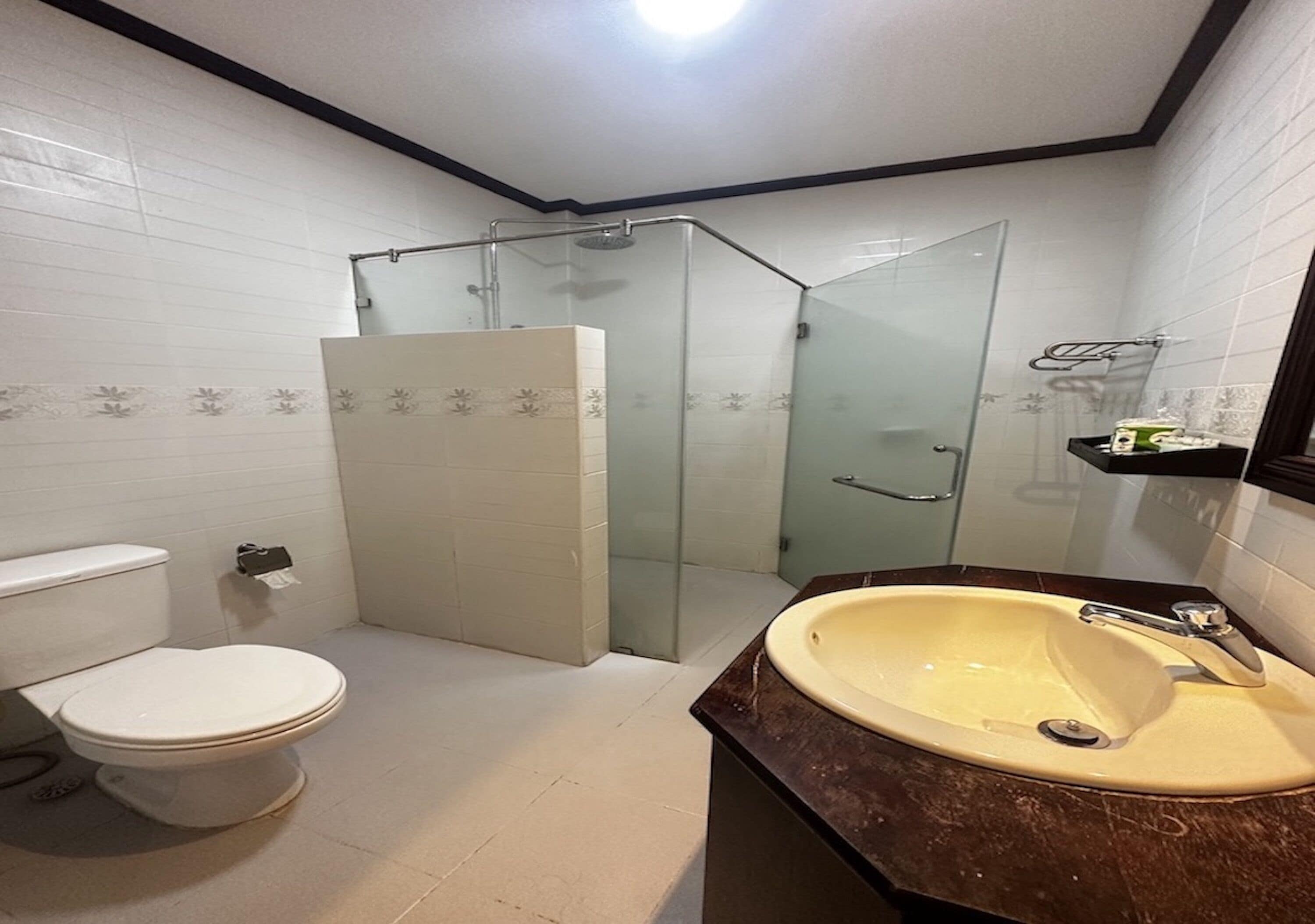 A bathroom with a toilet, a sink, and a glass-enclosed shower area.