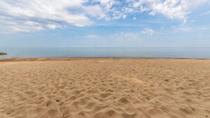 A sandy beach with a clear sky and calm sea. - Piccolo Cottage -  Great Location - Walking distance to Douglas Beach! (Douglas)
