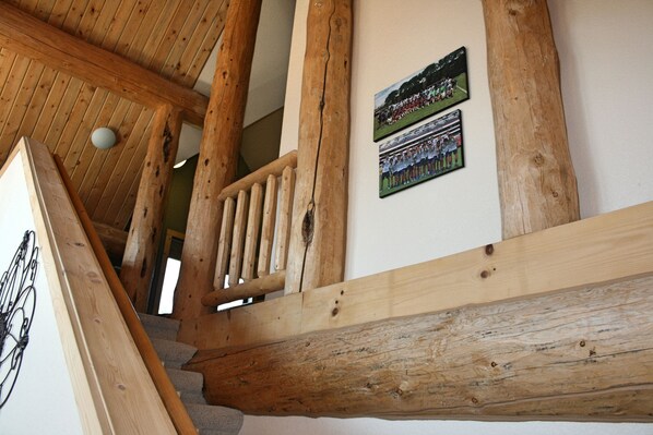 A wooden staircase with a handrail and a wall-mounted photo. - Classic Breckenridge Cabin with Modern Amenities and Million Dollar Views (Breckenridge)