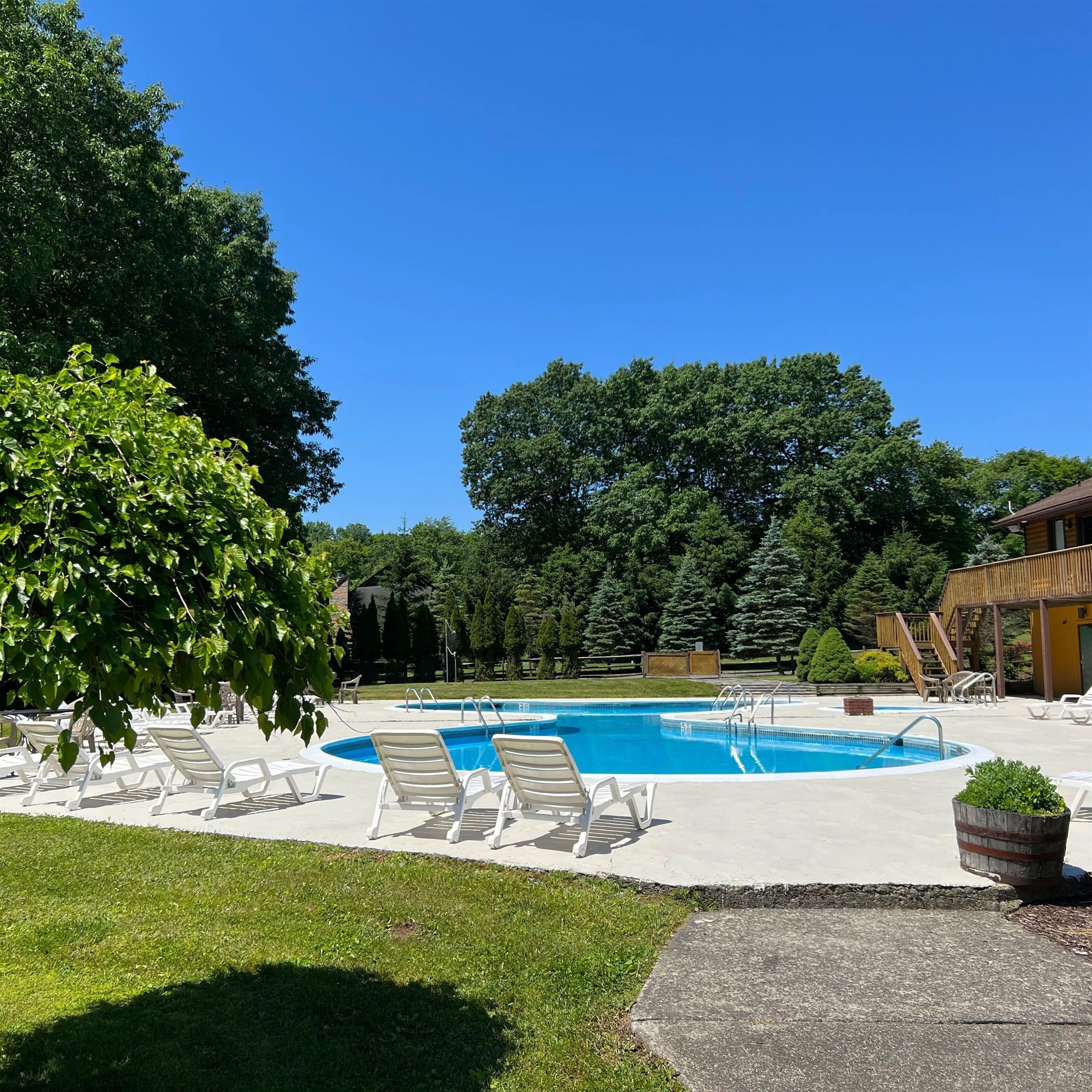 A swimming pool with lounge chairs and a wooden deck.