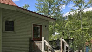 A wooden staircase leading to a porch with a red door and a window. - Village Hideaway, 1 bdrm efficiency, private entrance. On the Rail Trail. (Saranac Lake)