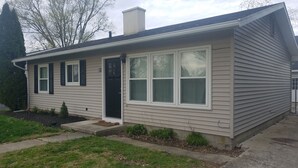 A single-story house with a front door, two windows with shutters, and a chimney. - Cozy 3 Bedroom Ranch No steps (Tiffin)