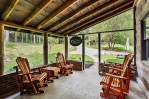 Un espace extérieur aménagé avec des sièges sous un abri, comprenant des fauteuils Adirondack et une enseigne indiquant « Chalet de ski ».