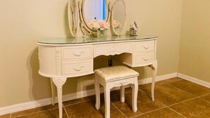 A white vanity with three mirrors, a bench, and a vase with flowers. - Paradise Palace and POOL home (Cape Coral)