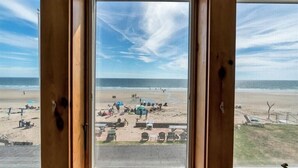 A beach view through a wooden-framed window with a clear sky. - Enjoy sunrises on the Private Beach - 4 bedrooms (Wells)