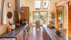 Une cuisine équipée d’une cuisinière, d’un évier et d’un coin repas avec des chaises et une table.