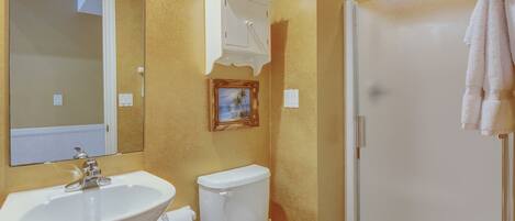 A bathroom with a sink, toilet, and shower.
