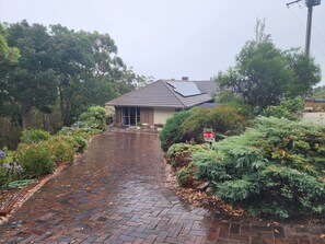 A house with a brick pathway leading to the entrance, surrounded by lush greenery and a 'No Parking' sign. - Sunset Hues-Enjoy Peace & Nature in lovely Adelaide Hills overlooking Adelaide (Norton Summit)