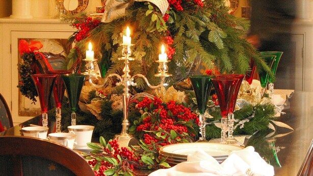 A dining table set with candles, red and green glassware, and festive decorations. - A Perfect Corner of the World  Historic Mansion Overlooking Niagara Gorge   (Lewiston)