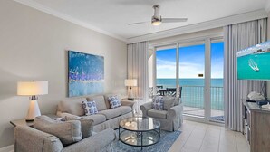 A modern living room with a sofa set, a glass coffee table, and a television. - Updated Leeward Key 1005, 2 bed/2 Bath, Beach Service beautiful condo (Miramar Beach)