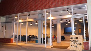 A FUJI GUEST HOUSE AO with a glass facade, seating area, and a signboard. - FUJI GUESTHOUSE AO - Hostel (Fujikawaguchiko)