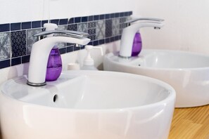 Two white sinks with modern faucets and a purple soap dispenser. - FUJI GUESTHOUSE AO - Hostel (Fujikawaguchiko)
