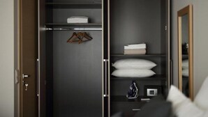 Ein begehbarer Kleiderschrank mit Regalen, Kleiderstange und Spiegel.