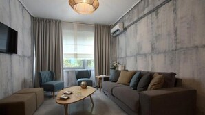 A modern living room with a sofa, armchairs, and a coffee table. - LeGeo-Luxurious Athenian Apartment (Athens)