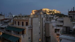 A cityscape with a prominent hilltop building illuminated at dusk. - LeGeo-Luxurious Athenian Apartment (Athens)