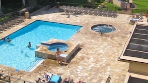 Une piscine avec un jacuzzi, des chaises longues et une vue sur l’océan.