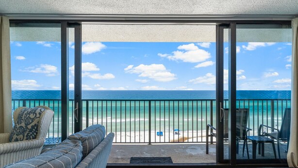 Un balcone con vista sull'oceano, un divano e un tavolo.