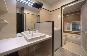 A modern bathroom with a white sink, mirror, and bathtub.