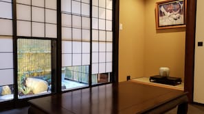Step into a serene Japanese-inspired retreat with a sliding screen door leading to a tranquil garden area.