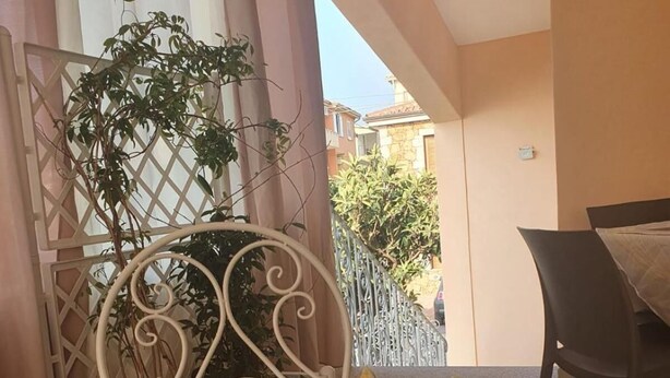 Una mesa con una bandeja de frutas, una silla metálica y una mesa de comedor con una silla.