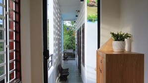 A corridor with a wooden cabinet and a fire extinguisher on the left. - Chez Le Anh (Da Nang)