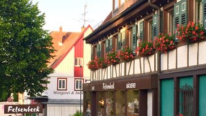 Ein traditionelles europäisches Gebäude mit einem Café namens 'Felsenbeck' und einem sichtbaren Schild für 'Metzgerei & Imb'.