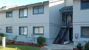 A multi-story residential building with a central staircase and a small front yard.