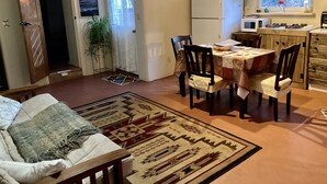 Un soggiorno accogliente con un divano, un tappeto decorato e un'area pranzo con tavolo e sedie.