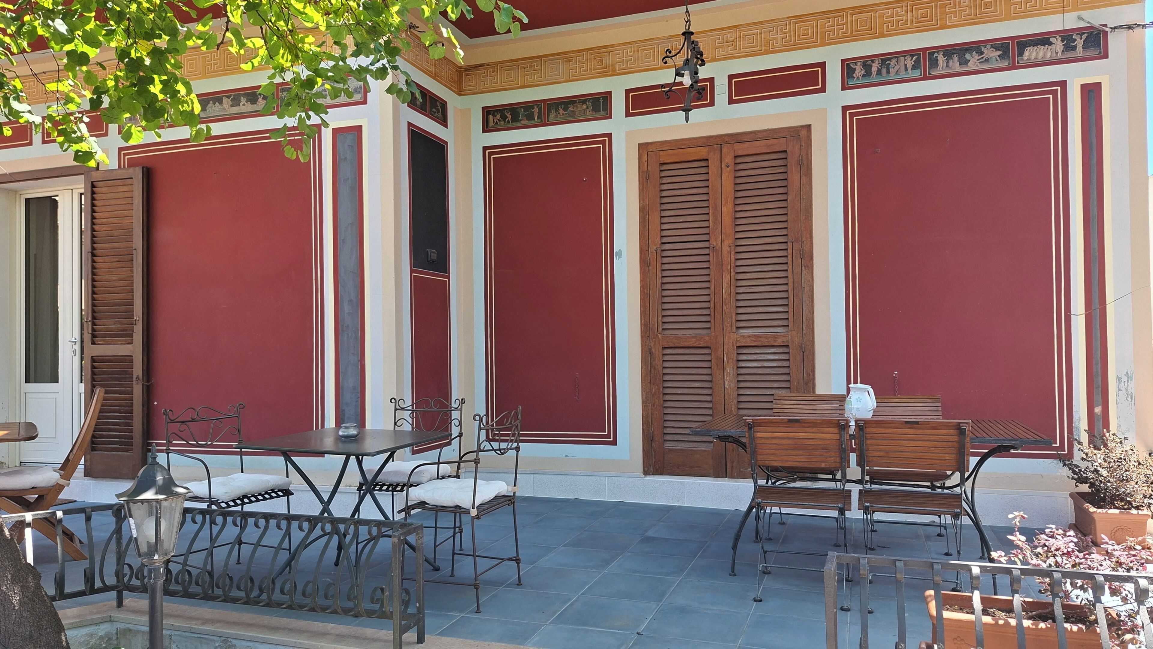 A patio with outdoor furniture, a staircase, and a door with shutters.